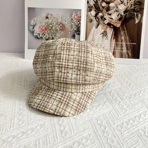 Detail of British plaid newsboy cap featuring sparkling rhinestones on textured fabric