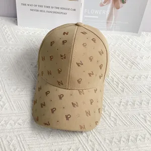 Détail d'une casquette de baseball kaki avec motifs de lettres en strass et visière incurvée