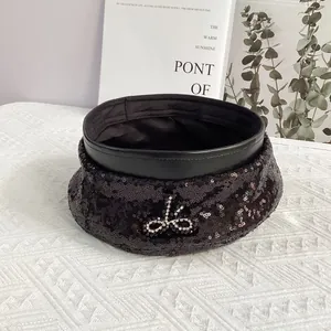 Détail du béret à paillettes noires avec nœud en strass et bordure en cuir de qualité