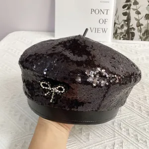 Détail d'un béret noir à paillettes avec nœud en strass brillant et bordure en cuir