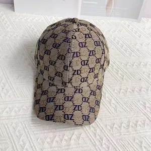 Top view of khaki canvas baseball cap featuring purple ZD monogram pattern and gold glitter
