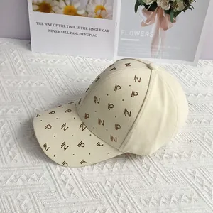 Détail de la casquette beige avec lettres en strass et motifs d'étoiles brillants