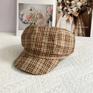 Detail view of British vintage plaid newsboy hat with sparkling rhinestones on brown fabric
