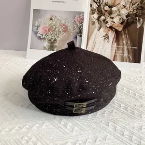 Detail of black glitter beret with dual leather straps and vintage gold metal buckles