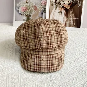 Detail of British style checkered newsboy hat with golden star-like metallic studs