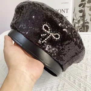 Vue détaillée du béret à paillettes noires avec un nœud en strass et bord en similicuir