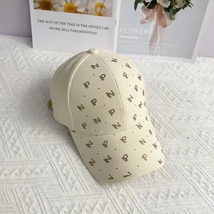 Gros plan sur la casquette beige avec un motif de lettres en strass étincelants