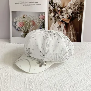 Detail of white newsboy cap featuring silver sequin fireworks and star embroidery