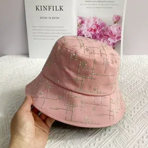 Detail eines rosa Fischerhuts aus Baumwolle mit goldenem Strass-Gittermuster und Blumen