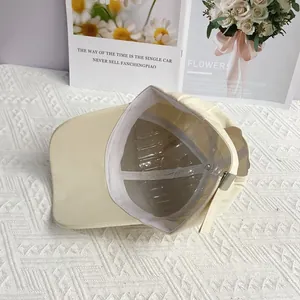 Détail de l'intérieur de la casquette crème avec coutures blanches et boucle de réglage