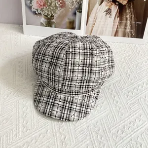 Detail of British style plaid newsboy hat with sparkling rhinestones on fabric