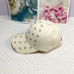 Détail d'une casquette crème avec motif de lettres B et d'étoiles en coton texturé