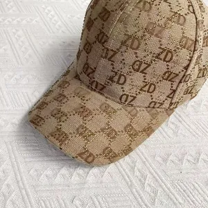 Close-up of khaki baseball cap featuring ZD jacquard pattern and sparkling gold rhinestones