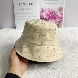 Detail eines beigen Fischerhutes mit geometrischen Strassmustern und Blumenakzenten