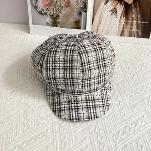 Close-up of black and white plaid newsboy hat with sparkly rhinestone embellishments
