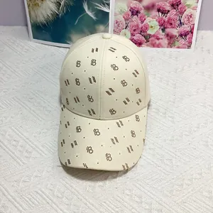 Détail d'une casquette en toile beige ornée de strass en forme de lettre B et d'étoiles