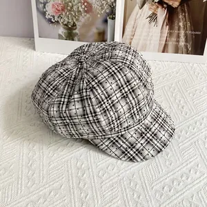Close-up of black and white checkered newsboy hat with sparkling rhinestone details