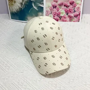 Détail de la casquette beige avec lettre B en strass marron et motifs d'étoiles