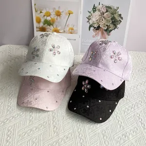 Detail of satin baseball caps with crystal flower embellishments in four colors