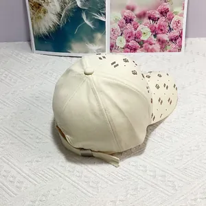 Détail de la sangle réglable avec boucle en métal argenté sur la casquette beige
