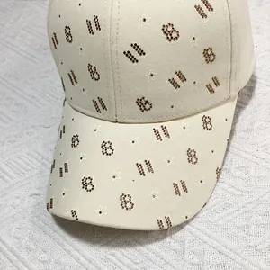 Vue détaillée d'une casquette beige avec strass en forme de lettre B et étoiles