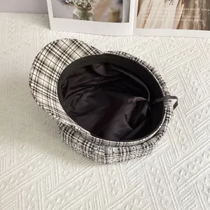 Detail of plaid newsboy cap showing black fabric lining and adjustable drawstring cord