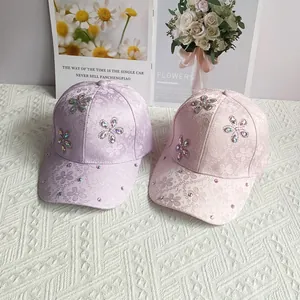 Detail of floral lace baseball cap with rhinestone flower embellishments and satin texture