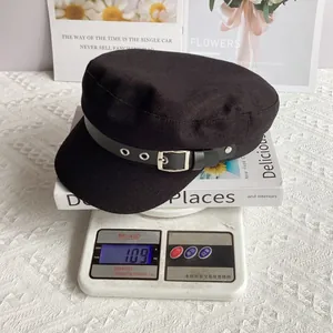 Detail of black military newsboy cap with leather strap and silver buckle weighing 109g