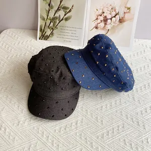 Denim cadet caps with studded rhinestones in dark grey and blue on a textured backdrop