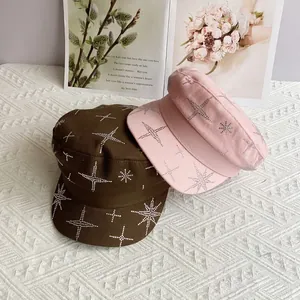 Casquettes plates avec étoiles en strass en marron et rose sur tissu texturé