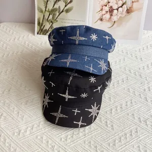 Détail de strass en étoile sur des casquettes gavroche en denim et coton au design plat