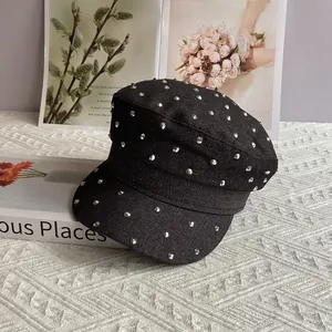 Detail view of black denim flat top military cap featuring silver metal studded rivets