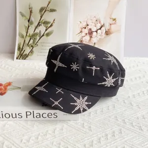 Détails des motifs d'étoiles en strass sur une casquette militaire noire en toile de coton
