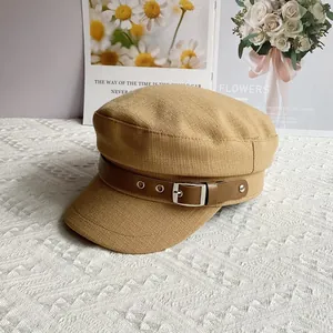 Detail view of the khaki cotton linen newsboy cap with vintage brown faux leather belt buckle