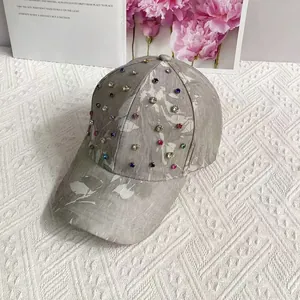 Detailed view of colorful rhinestones on a grey stone-patterned baseball cap