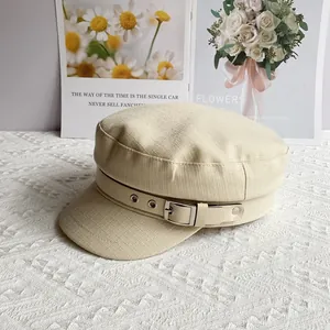Detailed texture of beige cotton linen baker boy hat with faux leather buckle strap