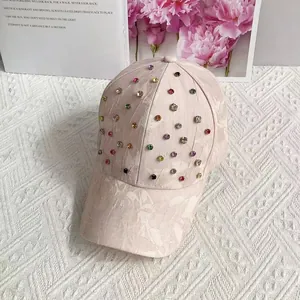 Close-up of pink lace baseball cap with sparkling colorful rhinestones and floral accents
