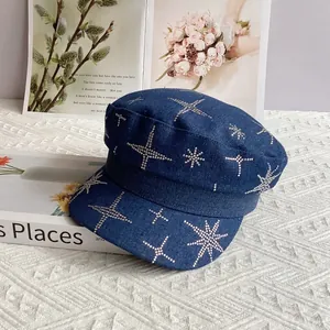 Détail des strass en forme d'étoile sur le denim bleu de la casquette militaire plate