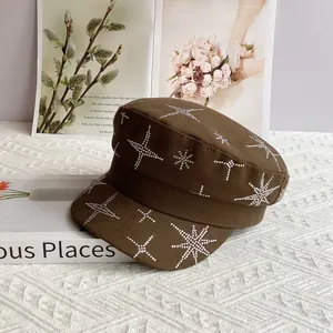 Détail d'une casquette gavroche marron en coton ornée d'étoiles en strass étincelantes