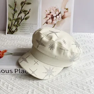 Détail de la casquette gavroche crème avec strass étoilés argentés sur le tissu