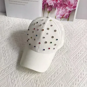 Detail of white cotton baseball cap featuring colorful hand-set crystal rhinestones