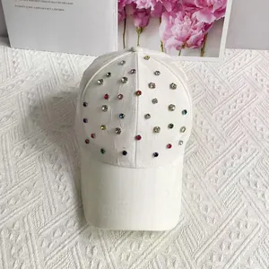 Close-up of scattered colorful rhinestones on a white faux leather baseball cap