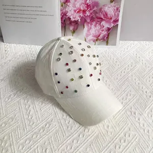 Detailed close-up of white baseball cap featuring vibrant multi-colored rhinestones