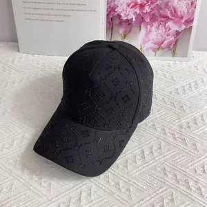 Détail d'une casquette noire avec des strass brillants formant un motif de lettre H chic