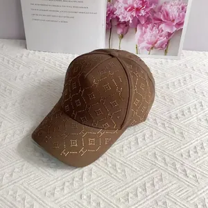 Détails d'une casquette marron avec motif H en strass dorés et rivets décoratifs