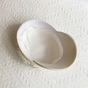 Vue détaillée de la casquette gavroche crème avec doublure satin et cordon réglable