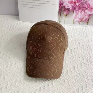 Détail d'une casquette marron avec des strass étincelants et motif de la lettre H