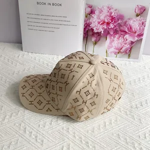 Gros plan détaillé de la casquette beige avec motifs H en strass et ornements cloutés