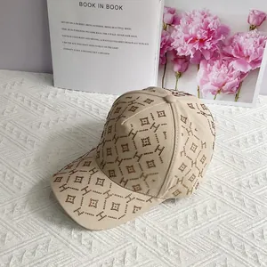 Gros plan sur une casquette beige avec motifs H en strass et texture géométrique