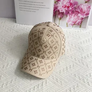 Détail de la casquette beige ornée de motifs en strass et de lettres H élégantes